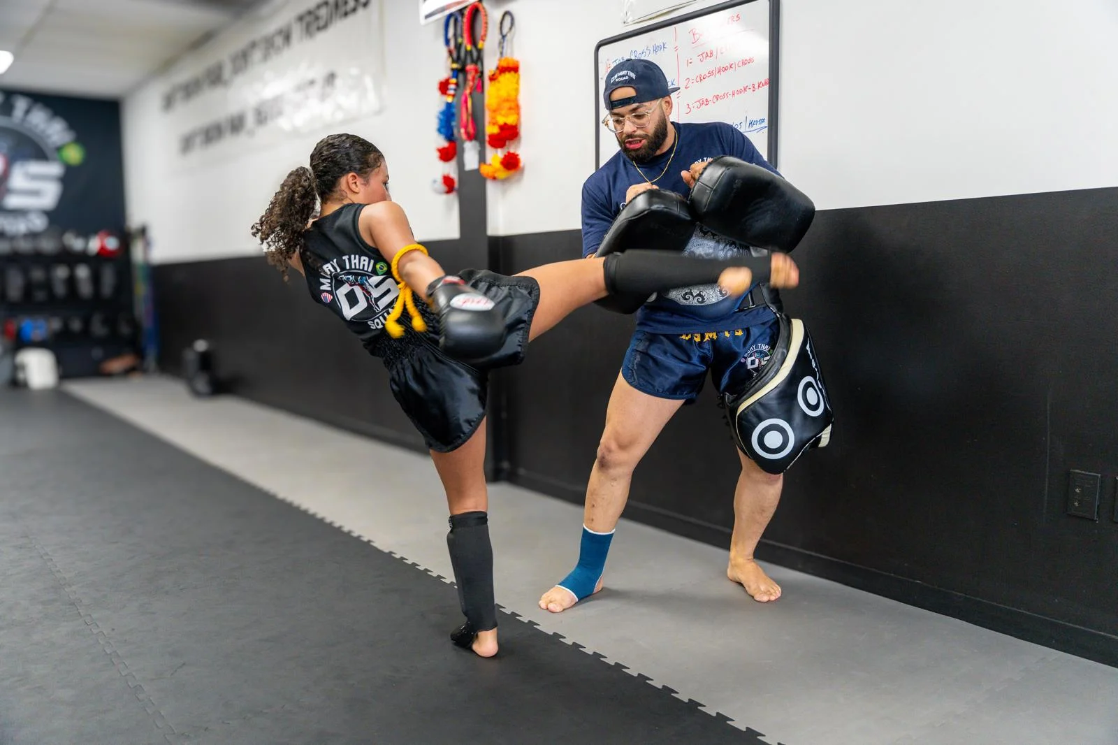 Student kicking pads held by the coach